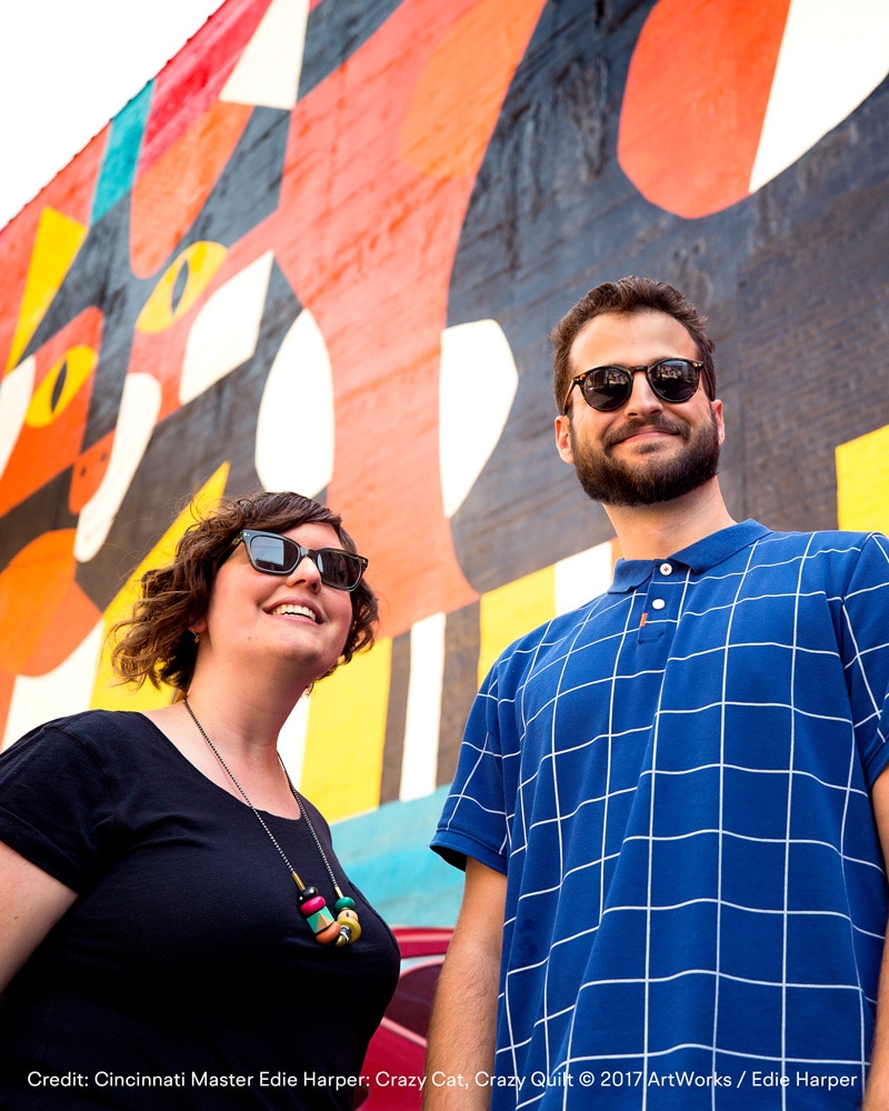 Barefoot employees standing in front of the Edie Harper Crazy Cat, Crazy Quilt mural