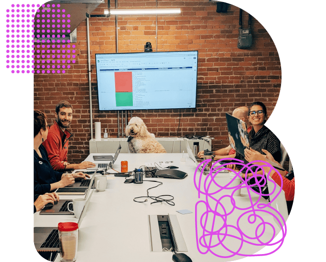 Employees and a dog meeting around a table