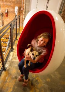 Employee sitting in a chair with their dog